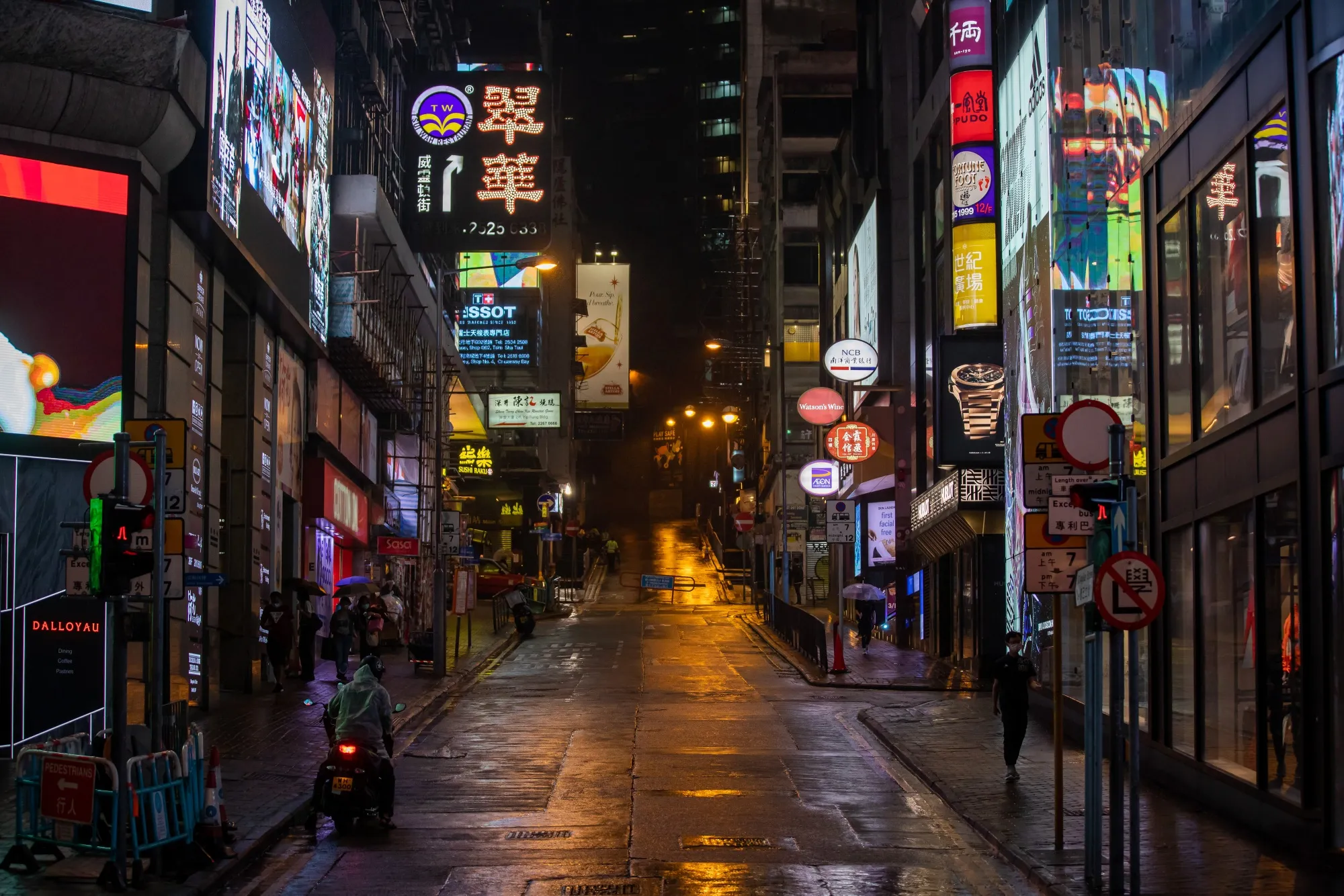Pedestrians walk along the near deserted Lan Kwai Fong at night in the Central district of Hong Kong, China, on Saturday, March 28, 2020.&nbsp;