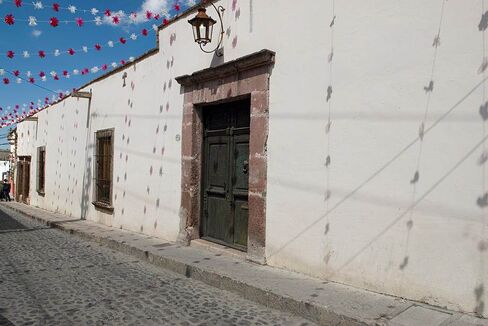 Outside, a nondescript stucco wall.