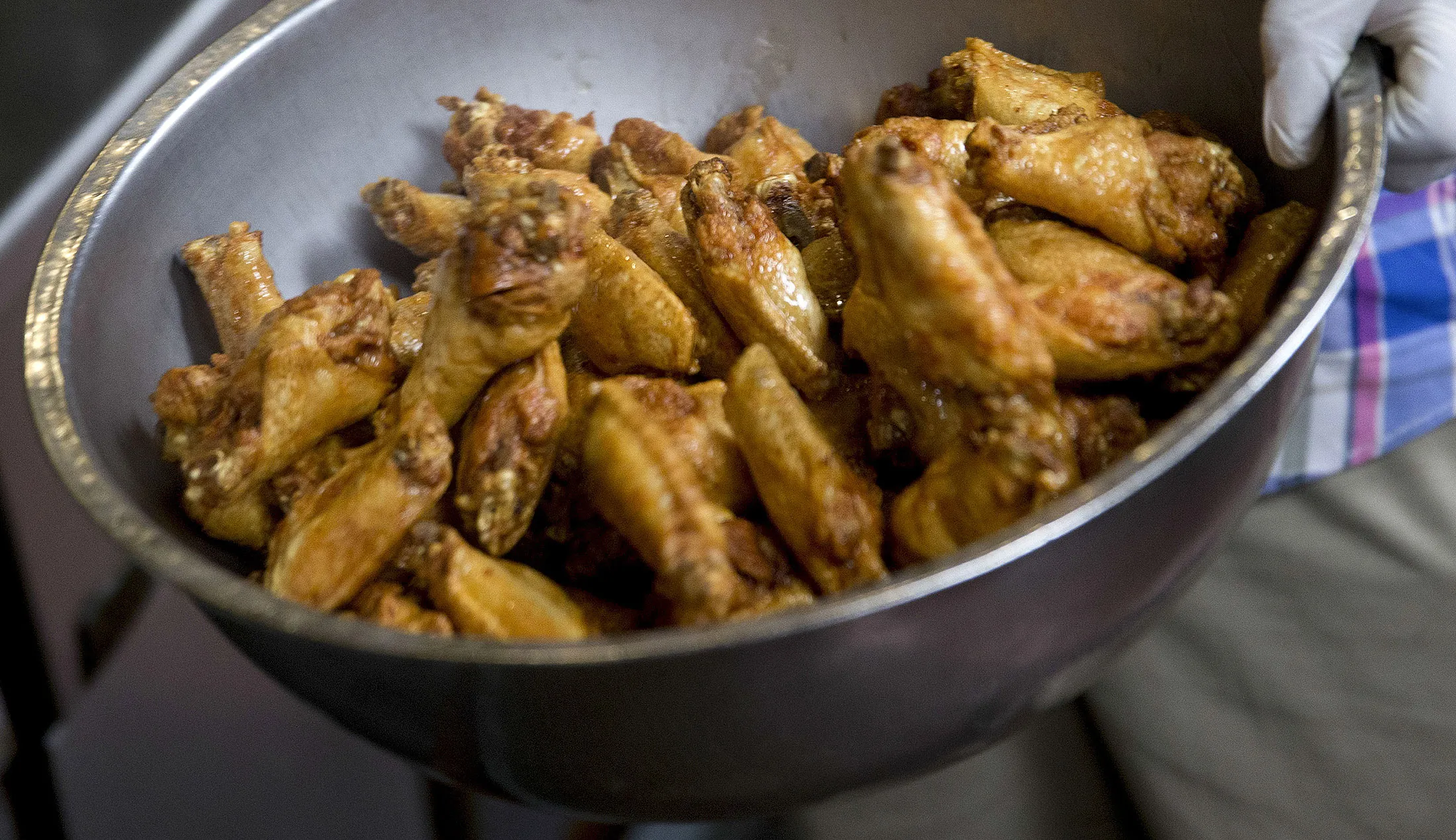 Chicken wings are removed from the fryer.
