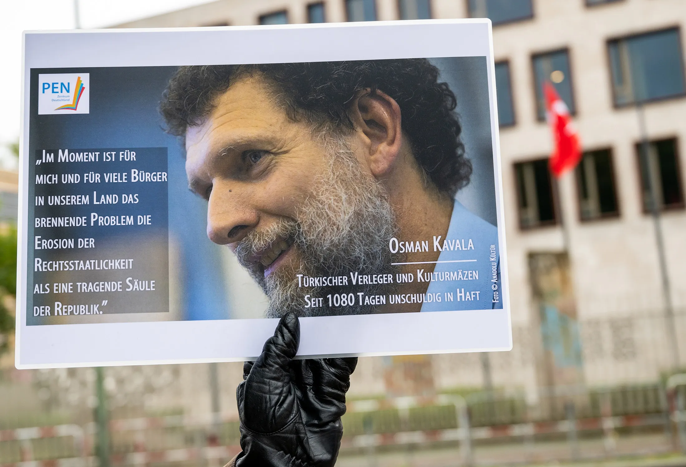A demonstrator holds a picture of Osman Kavala in front of the Turkish Embassy during a vigil in Berlin, Germany, on Oct. 15, 2020.&nbsp;