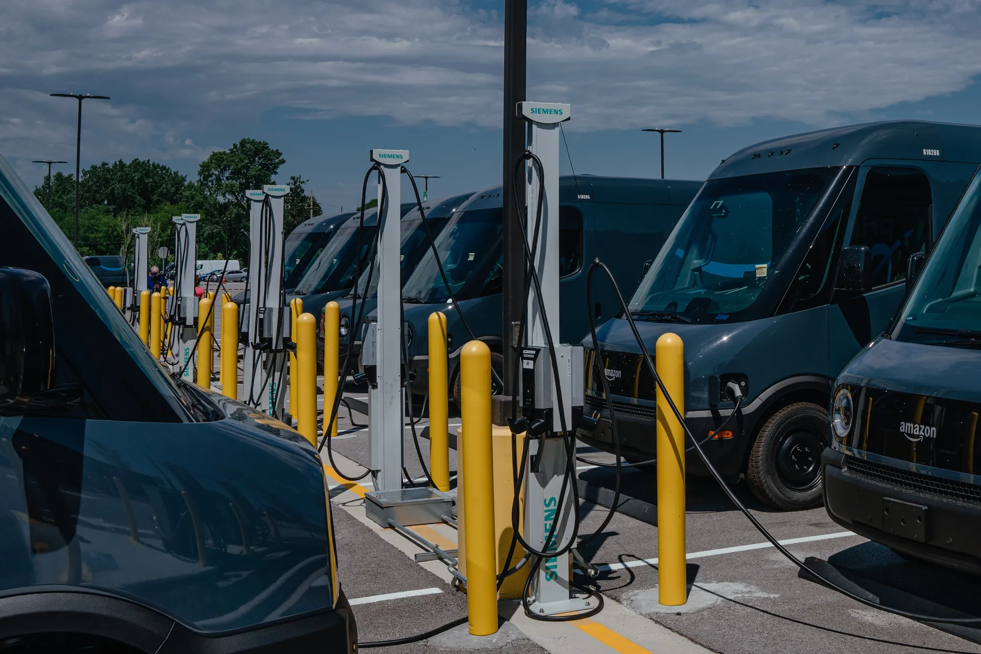 Amazon.com delivery electric vans, built by&nbsp;Rivian Automotive, at charging stations&nbsp;in Chicago.