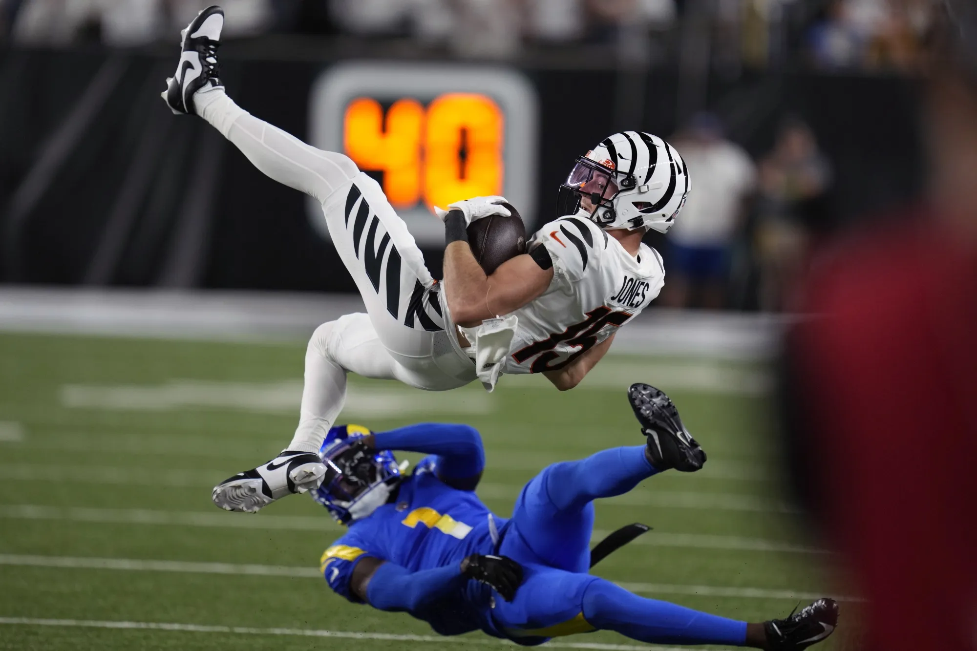 Cincinnati Bengals wide receiver Charlie Jones (15) is upended by Los Angeles Rams defensive back Derion Kendrick (1) during the first half of an NFL football game Monday, Sept. 25, 2023, in Cincinnati. (AP Photo/Michael Conroy)