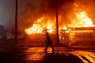 Thousands Flee From Uncontrolled Wildfires Burning Near LA
