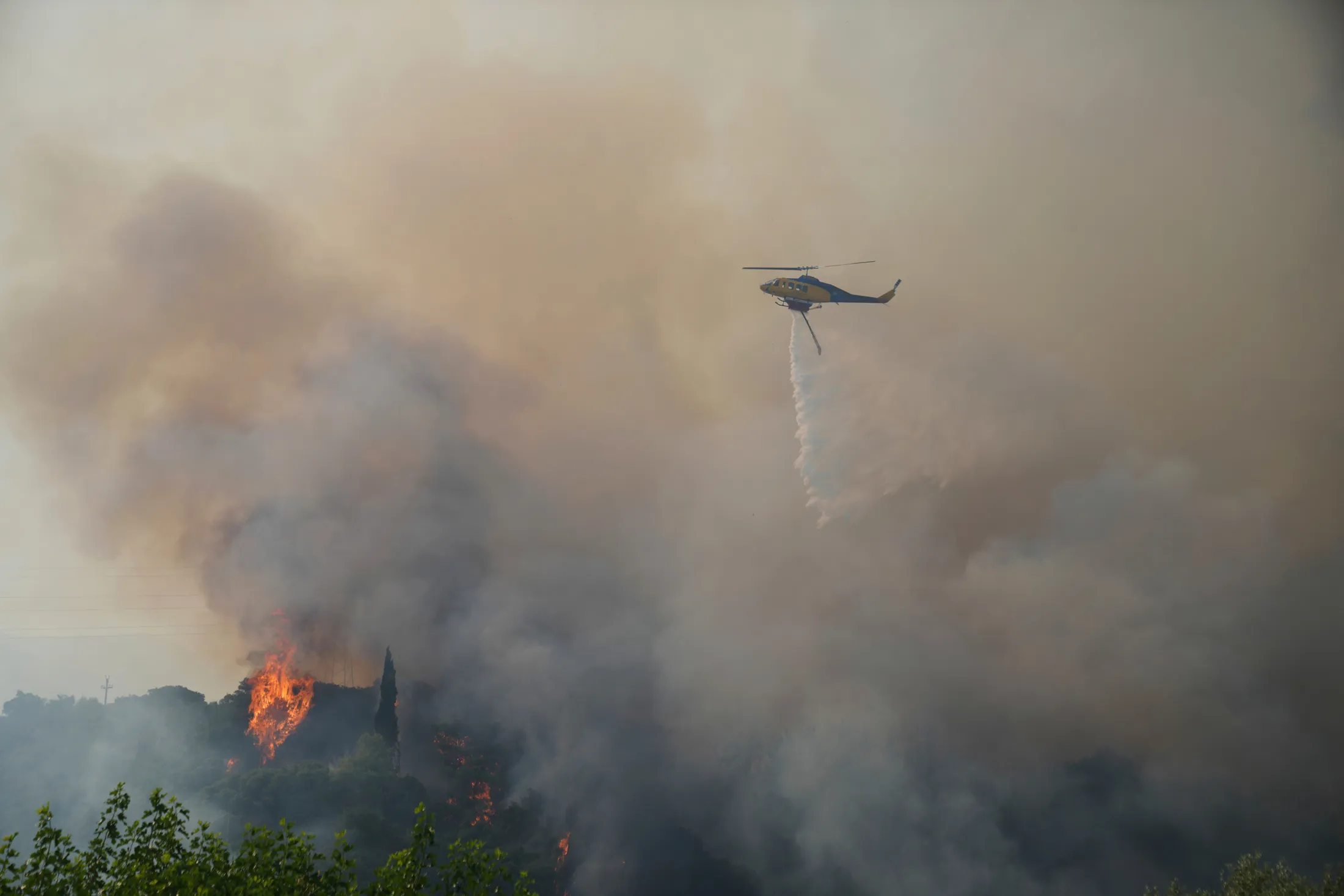 A firefighting helicopter dumps water on a wildfire near Patras, Greece on Aug. 13.