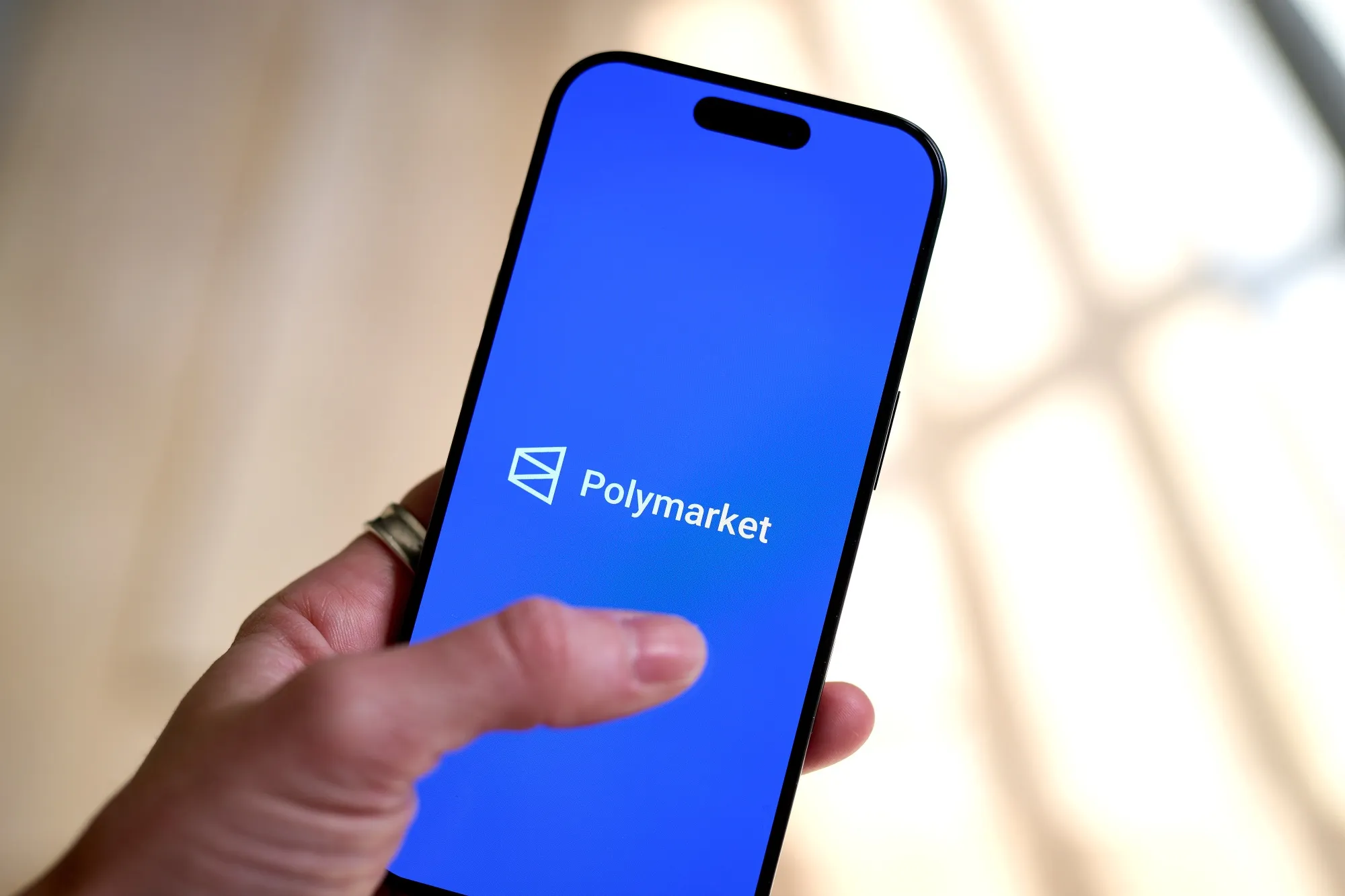 The Polymarket logo on a smartphone.