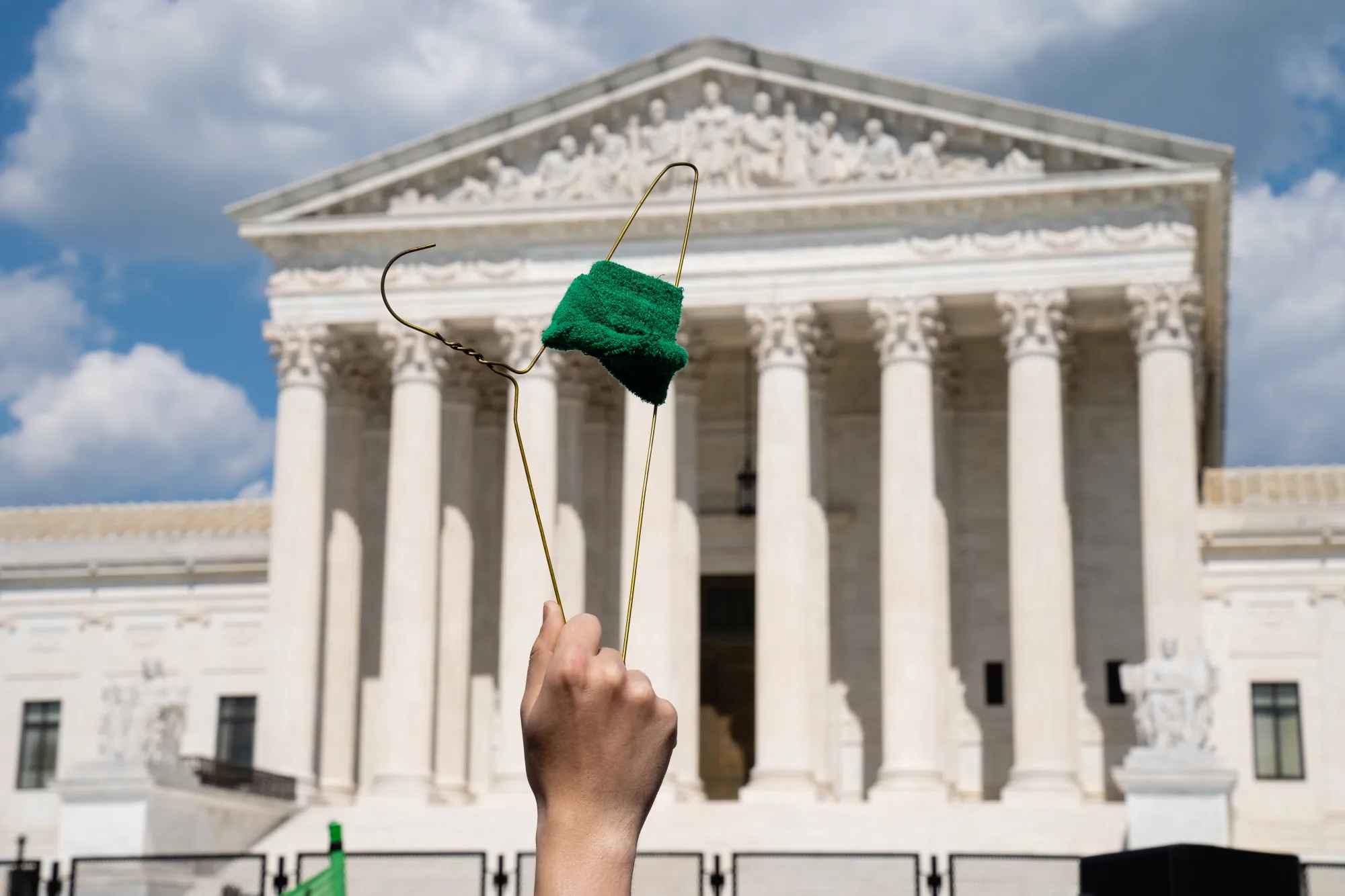An abortion rights demonstrator holds a coat hanger outside the US Supreme Court in Washington on&nbsp;June 25, 2022. The US Supreme Court&nbsp;overturned&nbsp;the 1973 Roe v. Wade decision Friday and wiped out the constitutional right to abortion, issuing a historic ruling likely to render the procedure largely illegal in half the country.