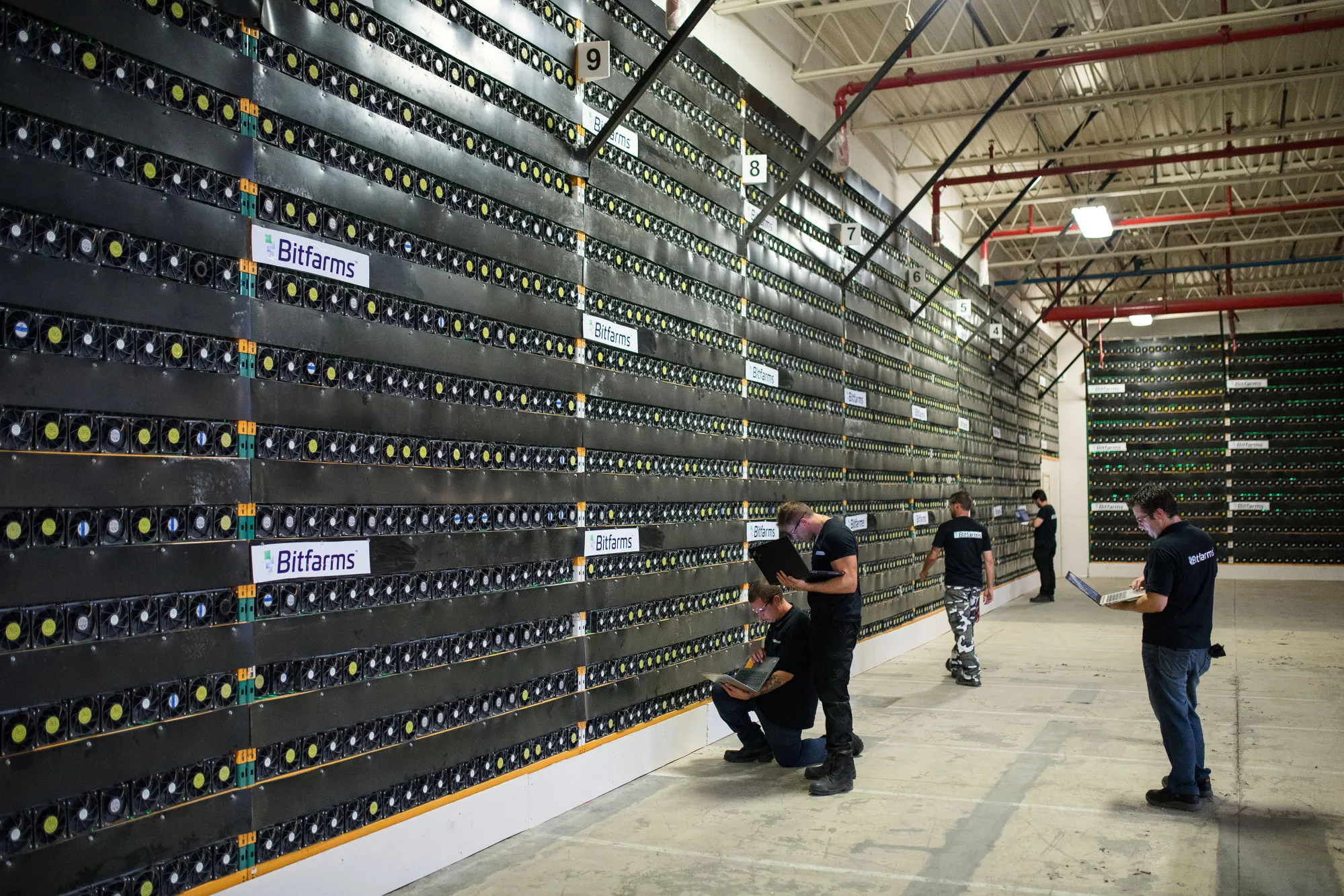 Technicians monitor cryptocurrency mining rigs at a Bitfarms facility in Saint-Hyacinthe, Quebec.