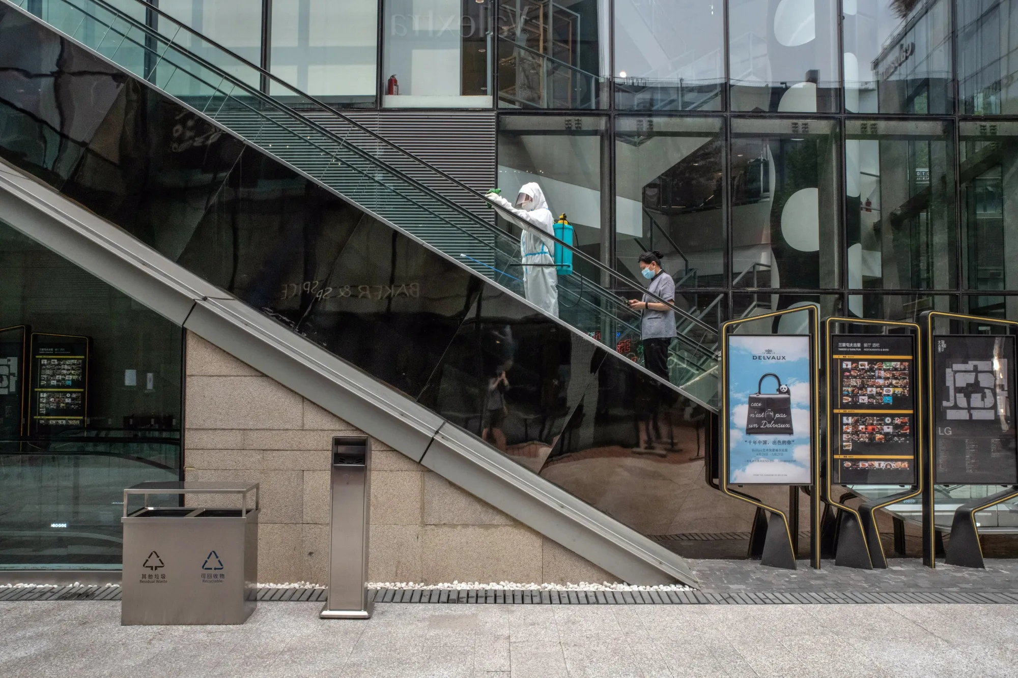 An employee disinfects an escalator at a shopping mall in Beijing, China, on Sunday, June 19, 2022.