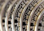 The embossed word Bitcoin sits on the edge of Bitcoins stacked in this arranged photograph in Danbury, U.K., on Thursday, Dec. 10, 2015. Bitcoin, the digital currency, climbed on Wednesday to hit its highest levels since early November, amid fresh speculation that the identity of Satoshi Nakamoto -- the virtual currency's creator -- may have finally been revealed.
