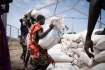 Women from Murle ethnic group carry bags of sorghum during a food distribution by United Nations World Food Programme in Gumuruk, South Sudan.