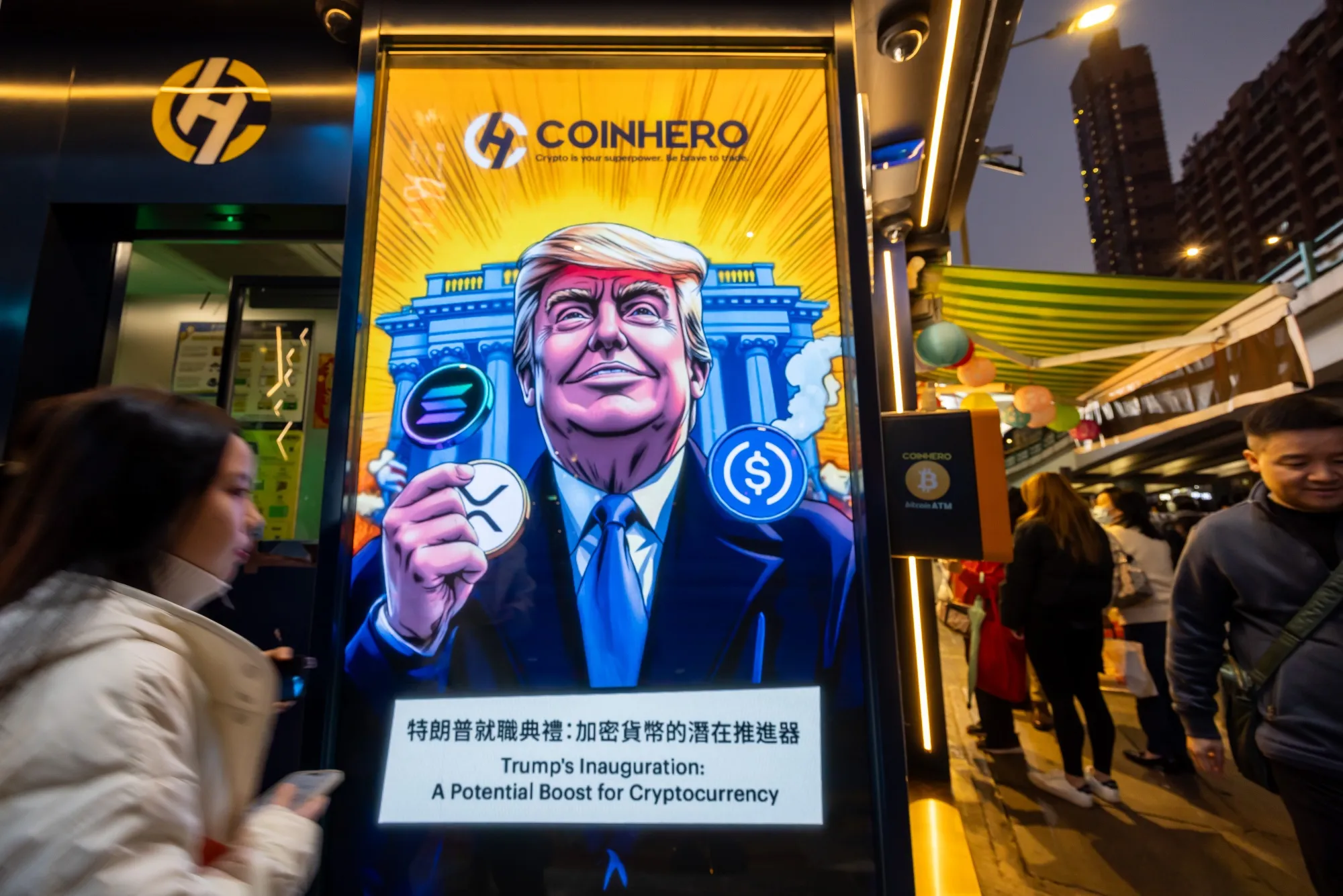 Una imagen de caricatura de Donald Trump con tokens de criptomonedas, representada frente a la Casa Blanca en una tienda en Hong Kong.
