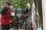 Matt Holmes, right, drains a suitcase while packing up belongings with his son, Gavin, 9, as the family is forced to leave their home left damaged by severe flooding in Fromberg, Mont., Friday, June 17, 2022. (AP Photo/David Goldman)