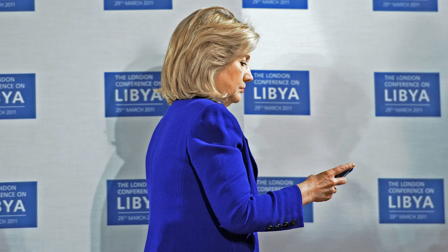 Secretary of State Hillary Clinton checks her phone at the opening of the Libyan Conference, a meeting of international allies to discuss the next steps for Libya, on March 29, 2011, in London.
