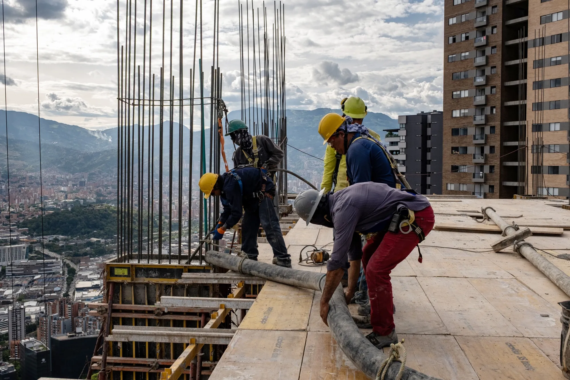Workers on the top floor of a building under construction in the Las Palmas neighborhood of Medellin, Colombia.