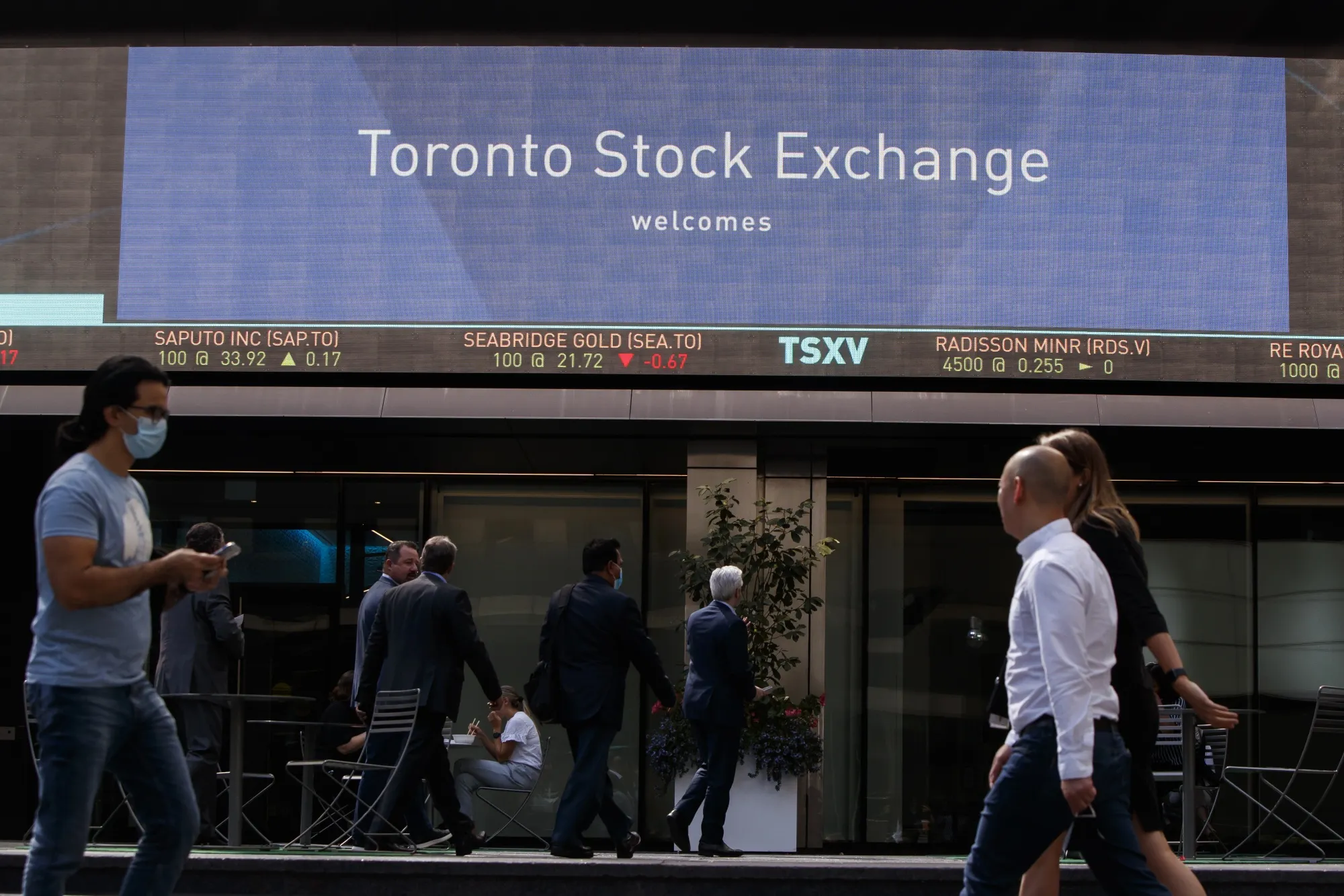 Pedestrians pass in front of the Toronto Stock Exchange.