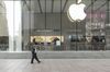 A police officer wearing a protective mask walks past a closed Apple store in Shanghai, China, on Feb. 5. 