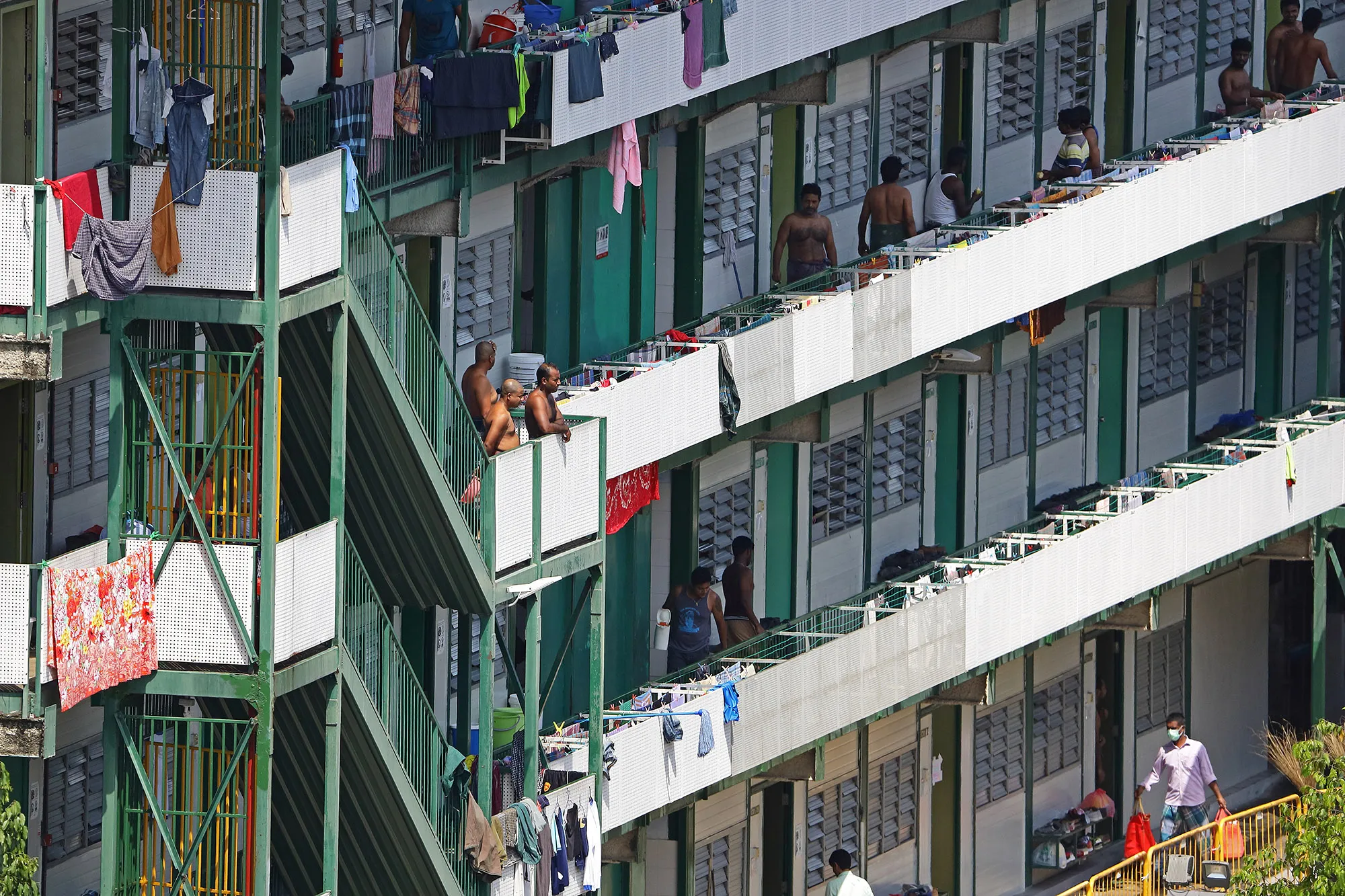 Foreign workers are seen outside their dormitory rooms in Singapore.