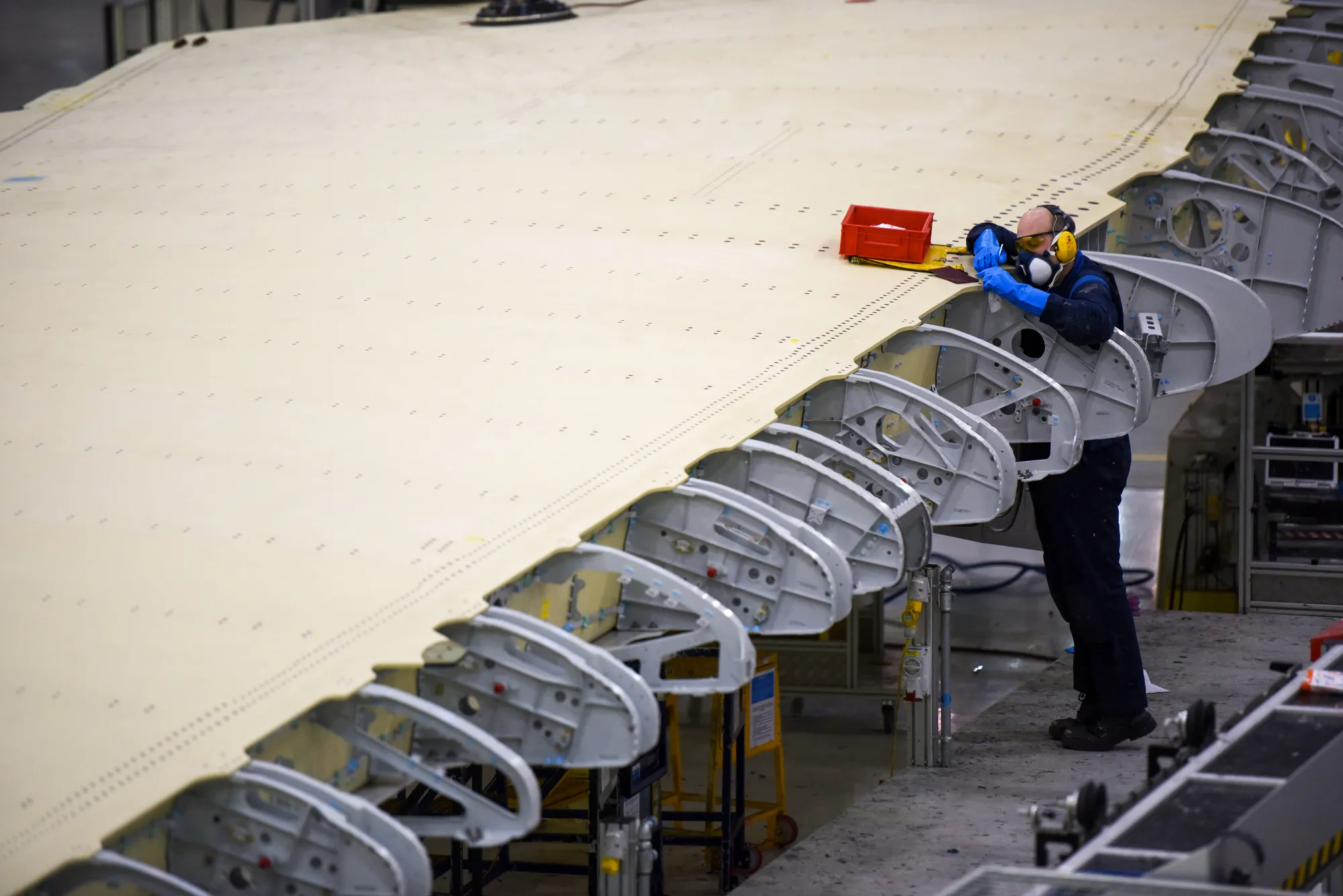 An employee works on a section of a wing on the Airbus A350 wing production line at the Airbus SE assembly factory in Broughton, U.K.