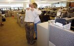 Reporters Gary Massaro, left, and Judi Villa hug in the newsroom of the Rocky Mountain News in Denver. The newspaper shuttered in 2009.
