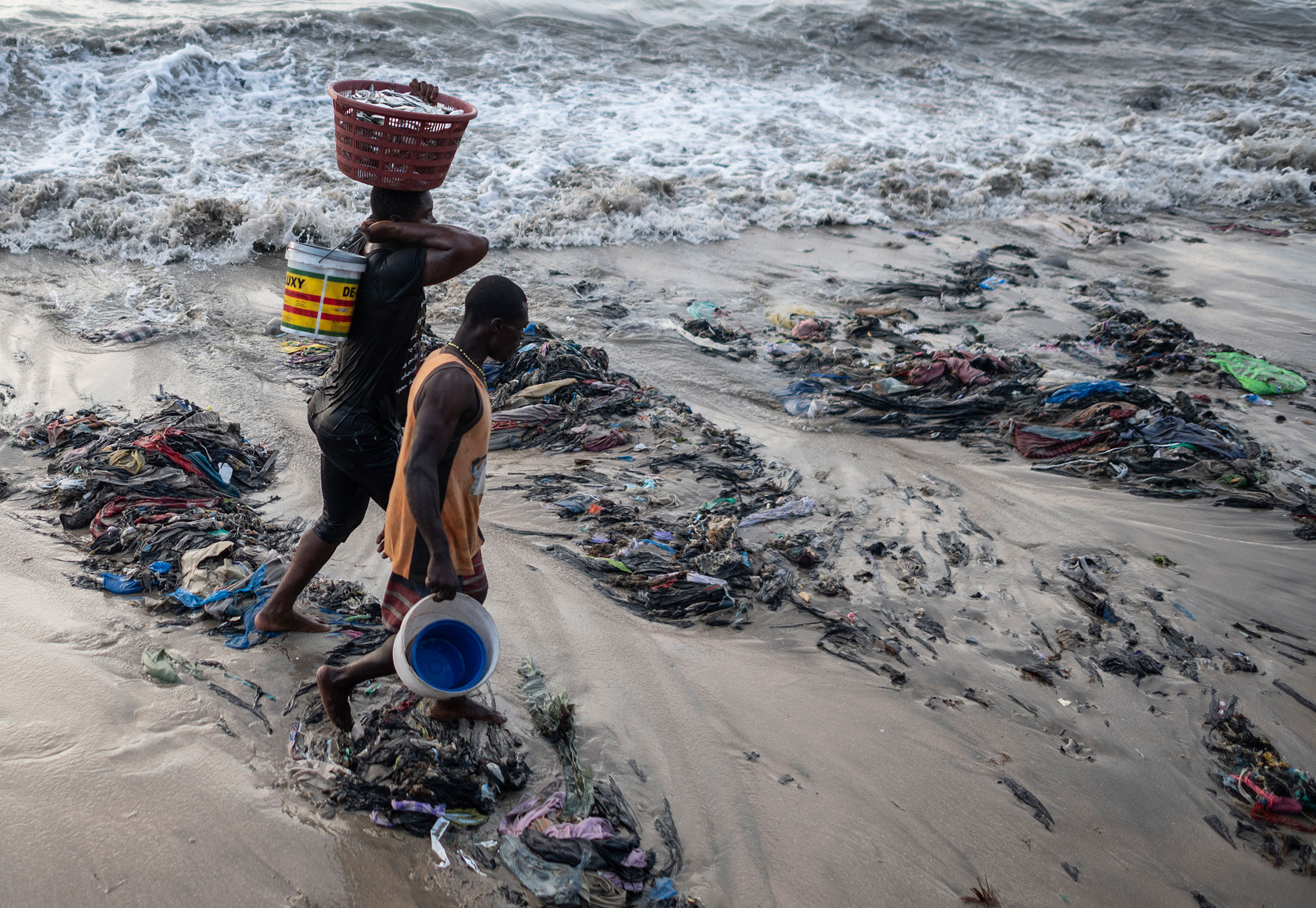 Fishermen walking across the refuse along Accra’s coastline.&nbsp;