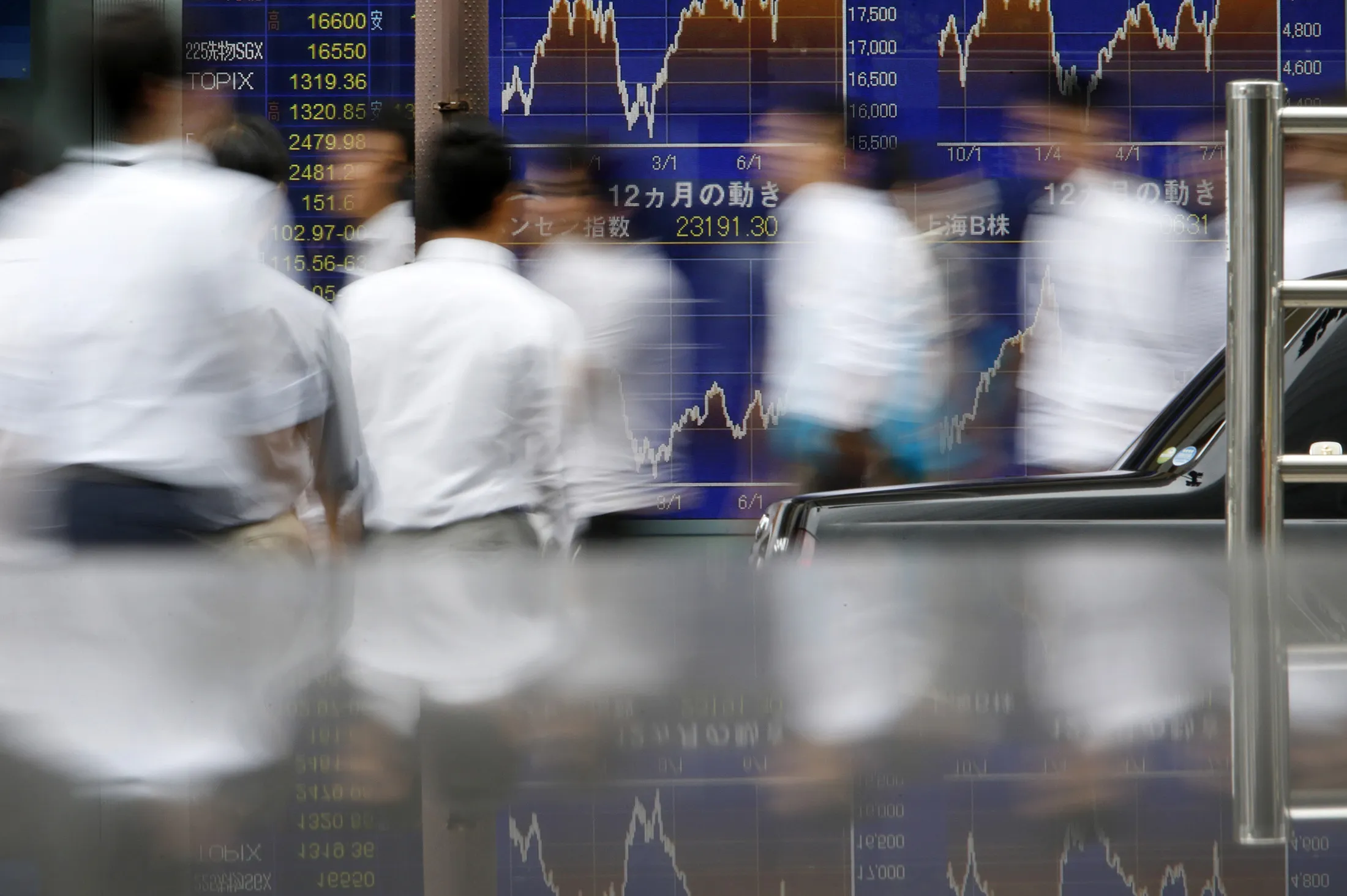 Pedestrians walk past an electronic stock board outside a securities firm in Tokyo, Japan, on Wednesday, Sept. 14, 2016. The Topix index fell for a sixth day at the close of trading in Tokyo as volatility returned to markets ahead of meetings by policy makers in Japan and the U.S. next week amid investor concern central banks around the globe may be reassessing the benefits of existing stimulus measures.
