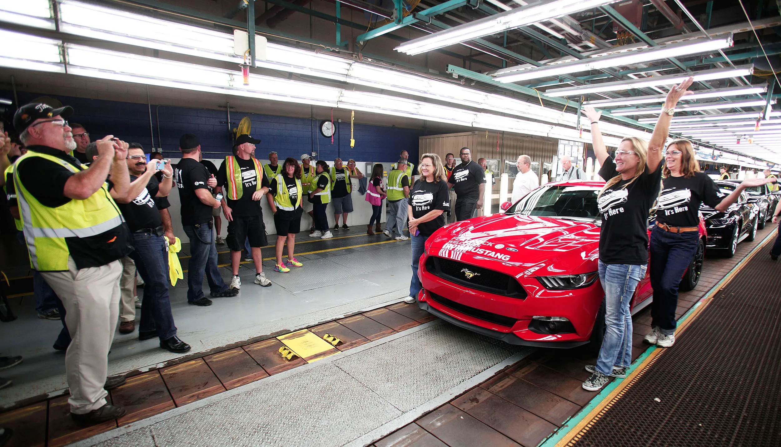 Workers pose with a 2015 Ford Mustang off the assembly line at the Ford Flat Rock Assembly Plant in Michigan.
