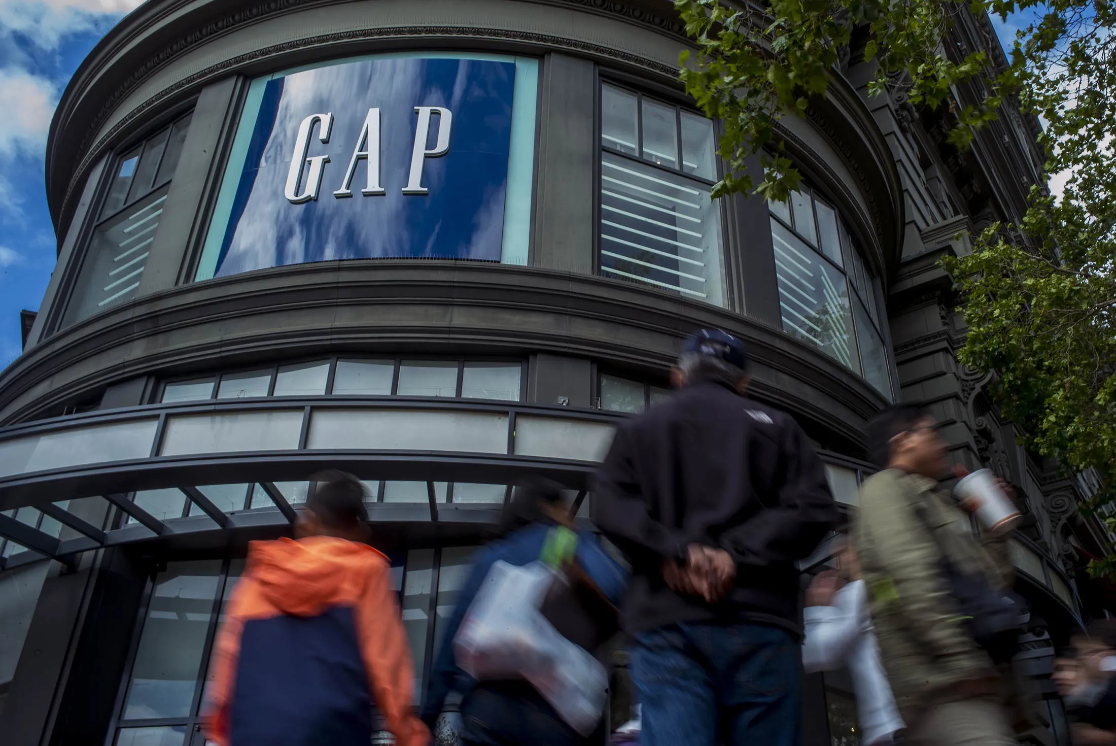 Pedestrians walk past a Gap Inc. store in San Francisco, Calif.
