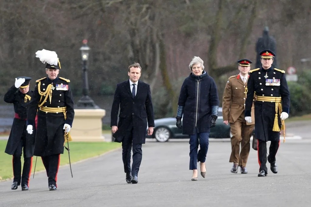 Emmanuel Macron and Theresa may, out in the cold.
