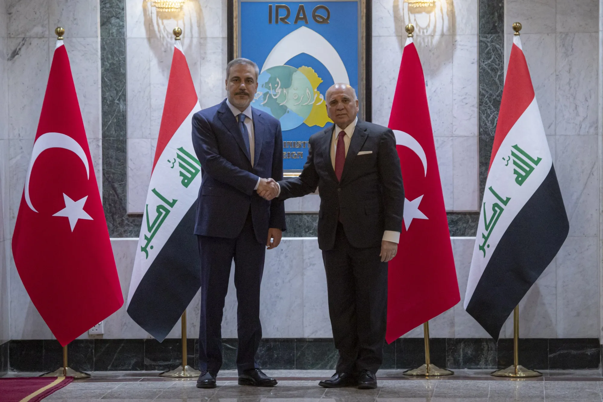 Iraqi Foreign Minister Fuad Hussein, right, with Turkey’s&nbsp;Hakan Fidan in Baghdad on March 14.