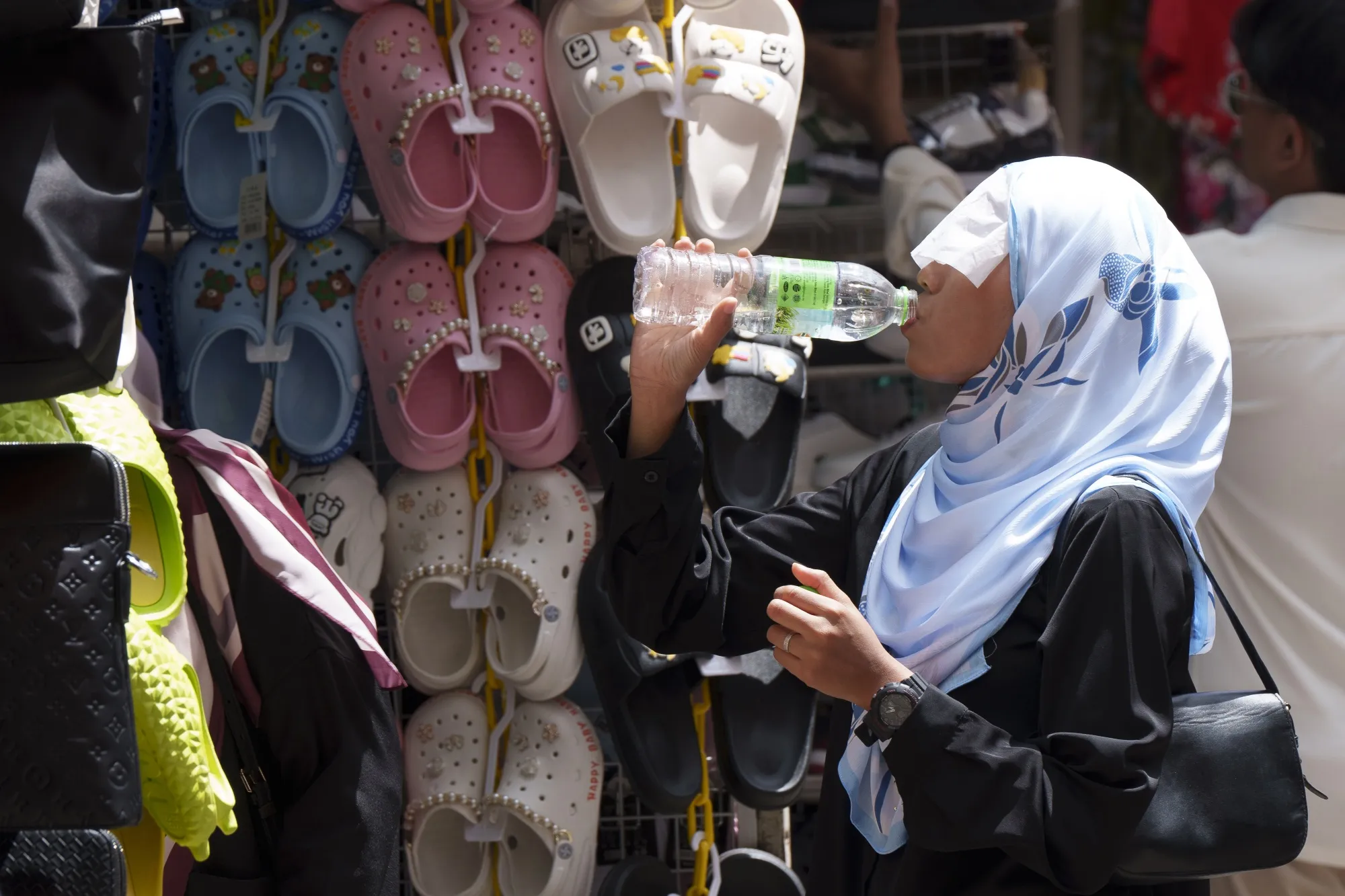 A girl drinks water under the hot sun in downtown Kuala Lumpur, Malaysia. on May 9.