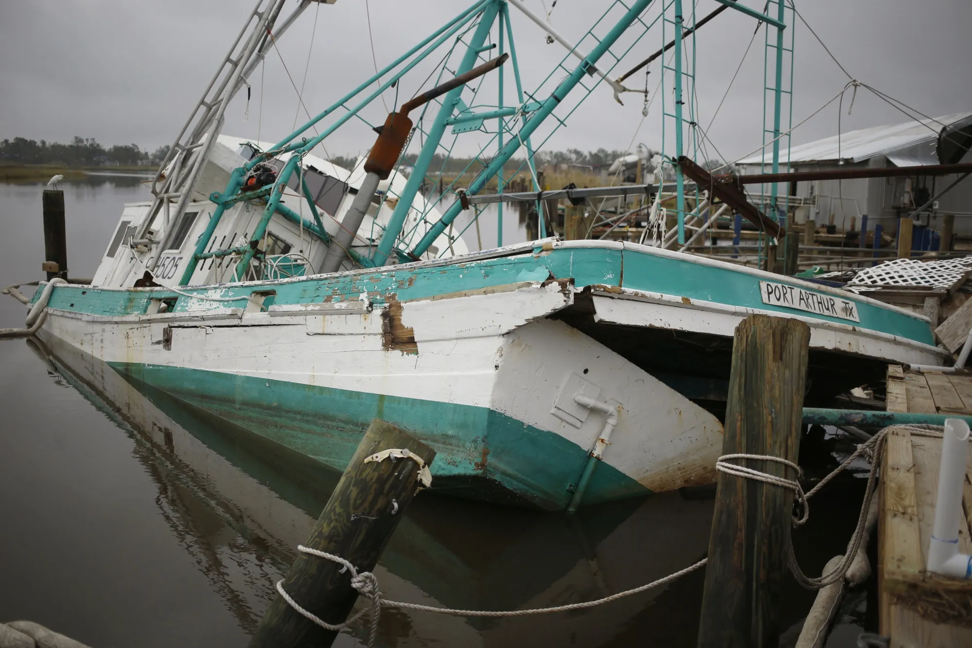 A shrimp boat sits damaged at a dock after Hurricane Delta made landfall in Hackberry, Louisiana in October 2020.
