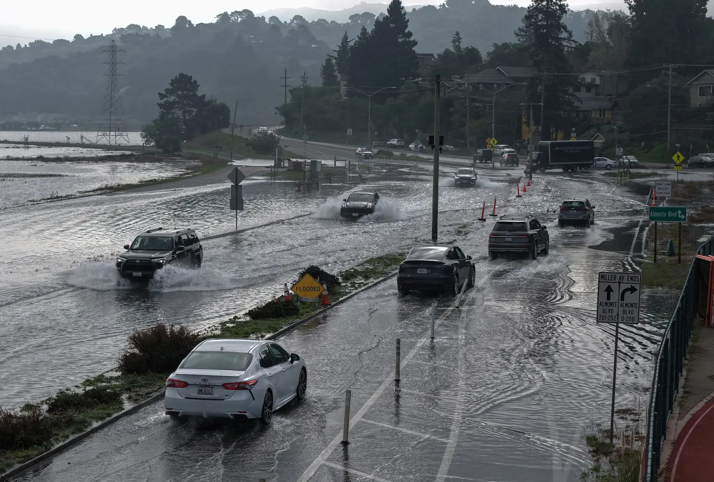 Cars drive along a street flooded with seawater&nbsp;in Mill Valley, California.
