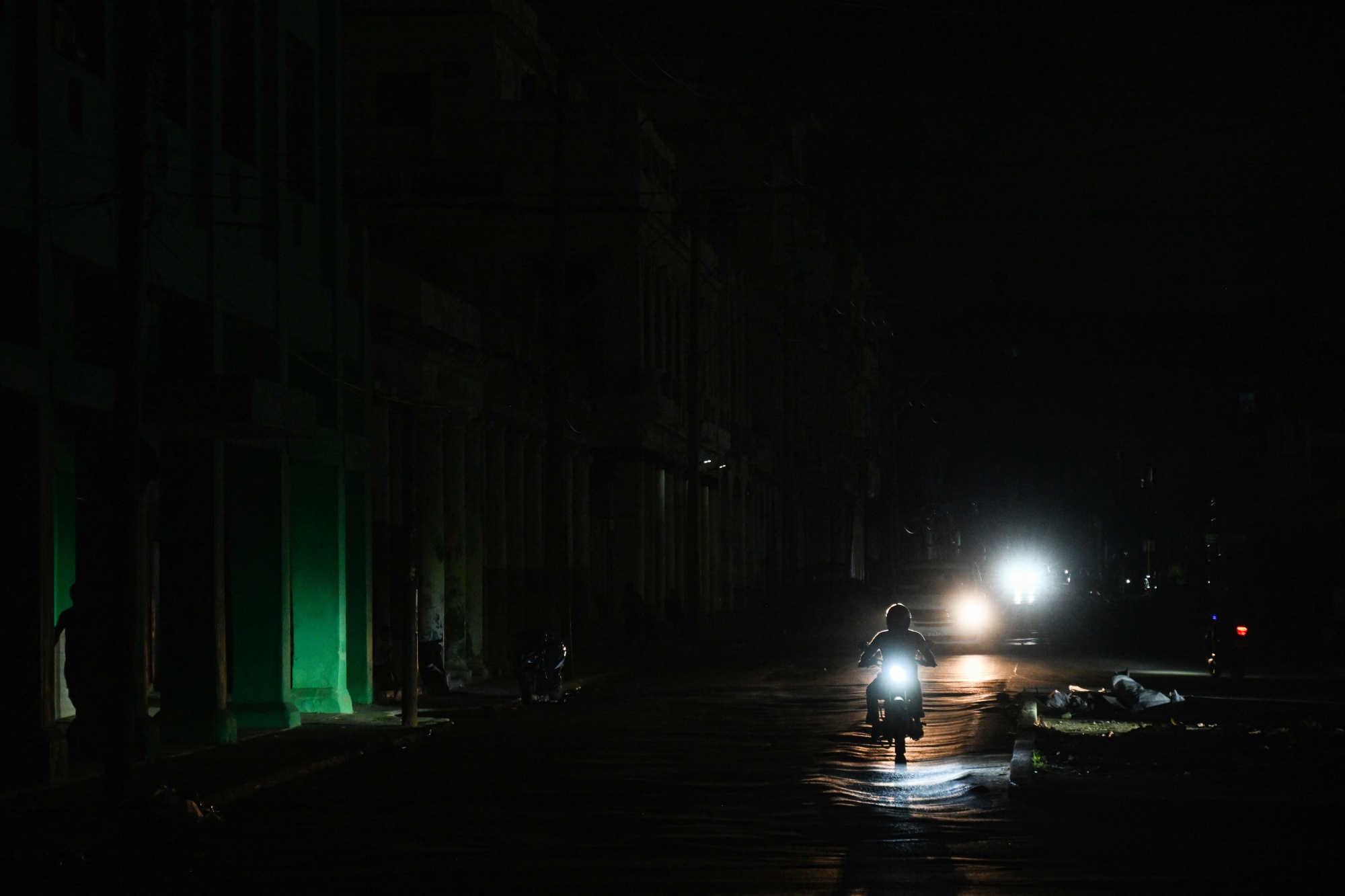 A motorcyclist rides on a street during a blackout in Havana on Jan. 25. Photographer: Yamil Lage/AFP/Getty Images