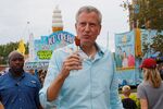 New York Mayor Bill de Blasio eats a corn dog at the Iowa State Fair during his campaign for president.