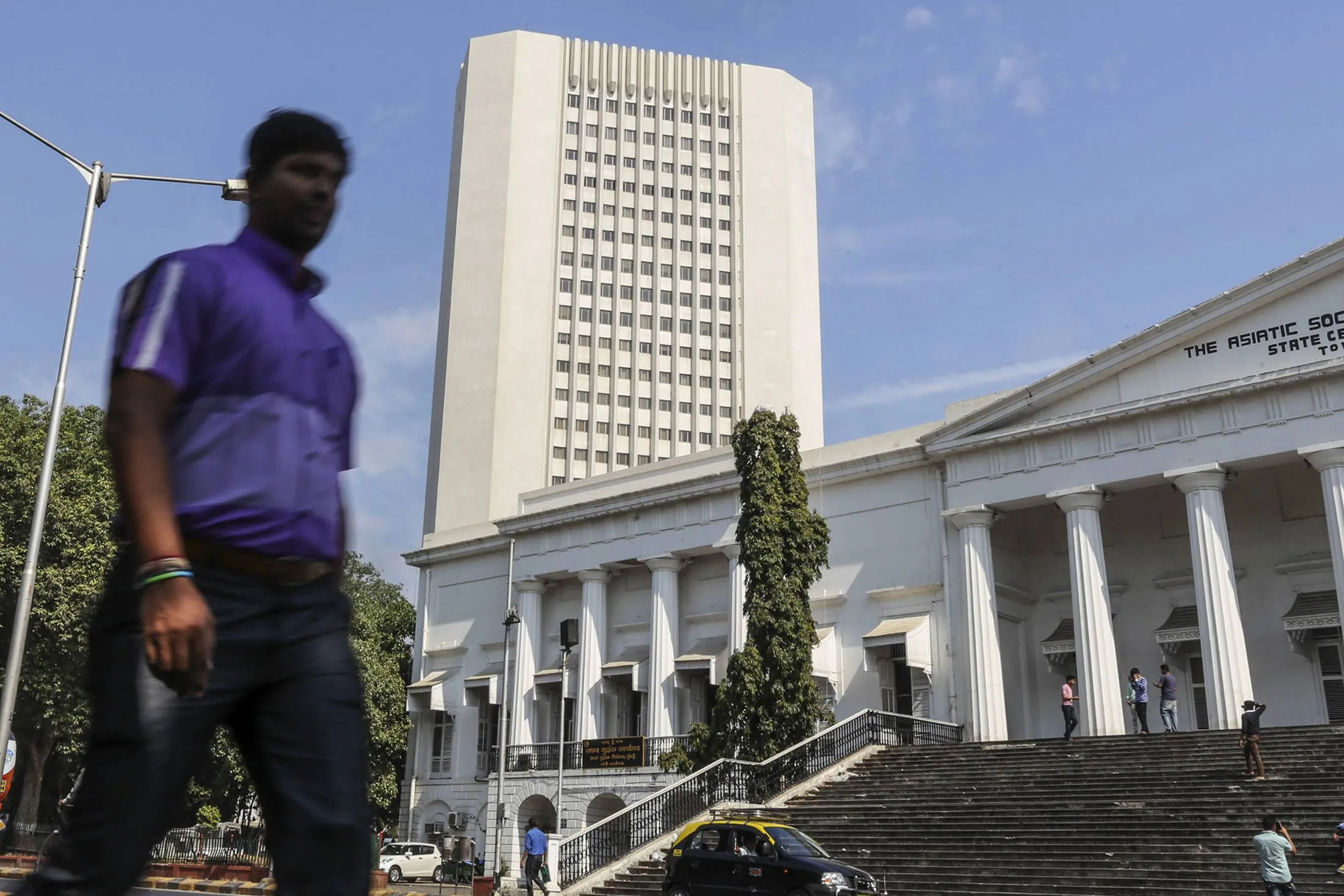 Pedestrians walk past the Reserve Bank of India headquarters in Mumbai.
