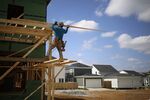 A contractor stands on lumber scaffolding while working on a home under construction&nbsp;in Louisville, Kentucky.