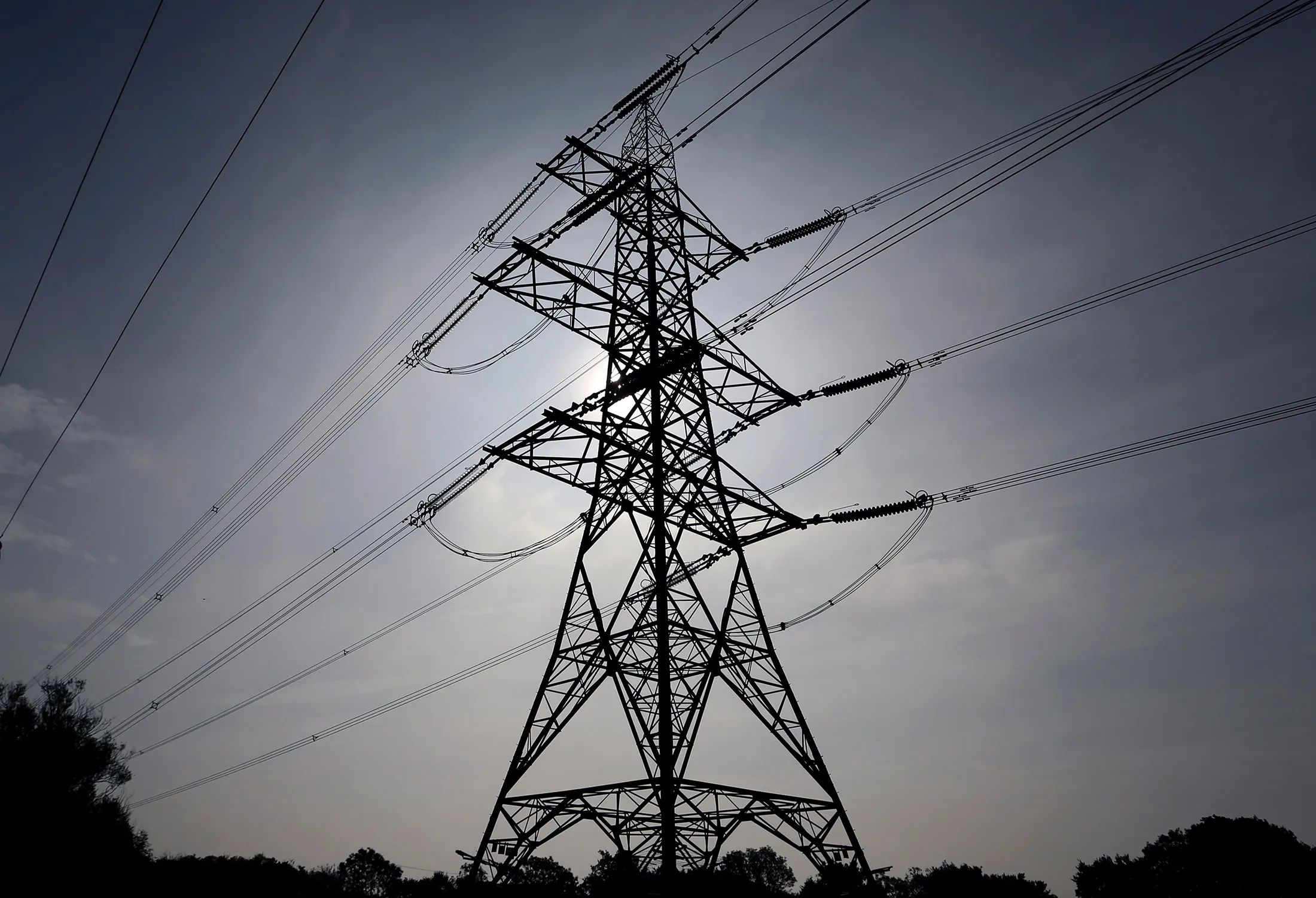 Power transmission lines run from an electricity pylon in Braintree, U.K., on Wedenesday, Sept. 25, 2013. Britain's business lobby groups said that Labour leader Ed Miliband opposition's proposal to break up the 'Big Six' utilities and cap power prices threatens the investment needed to avoid blackouts by the end of the decade.
