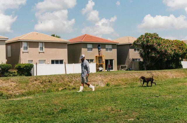 Kimmel and Trouble walk near houses after retrieving an iguana.