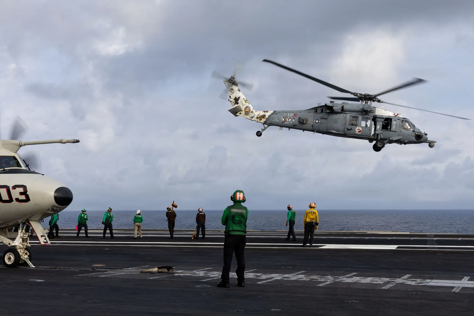 U.S. Sailors observe an MH-60S Sea Hawk helicopter take off from the flight deck of USS Gerald R. Ford.&nbsp;