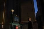 A pedestrian walks towards an entrance to the Wall Street subway station near the New York Stock Exchange.