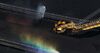 A stacker-reclaimer operates next to stockpiles of coal as a rainbow forms in a spraying jet of water at the Newcastle Coal Terminal in this aerial photograph taken in Newcastle, Australia.