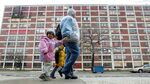 A family&nbsp;walks past Chicago’s&nbsp;now-demolished Cabrini-Green public housing buildings in 2005.