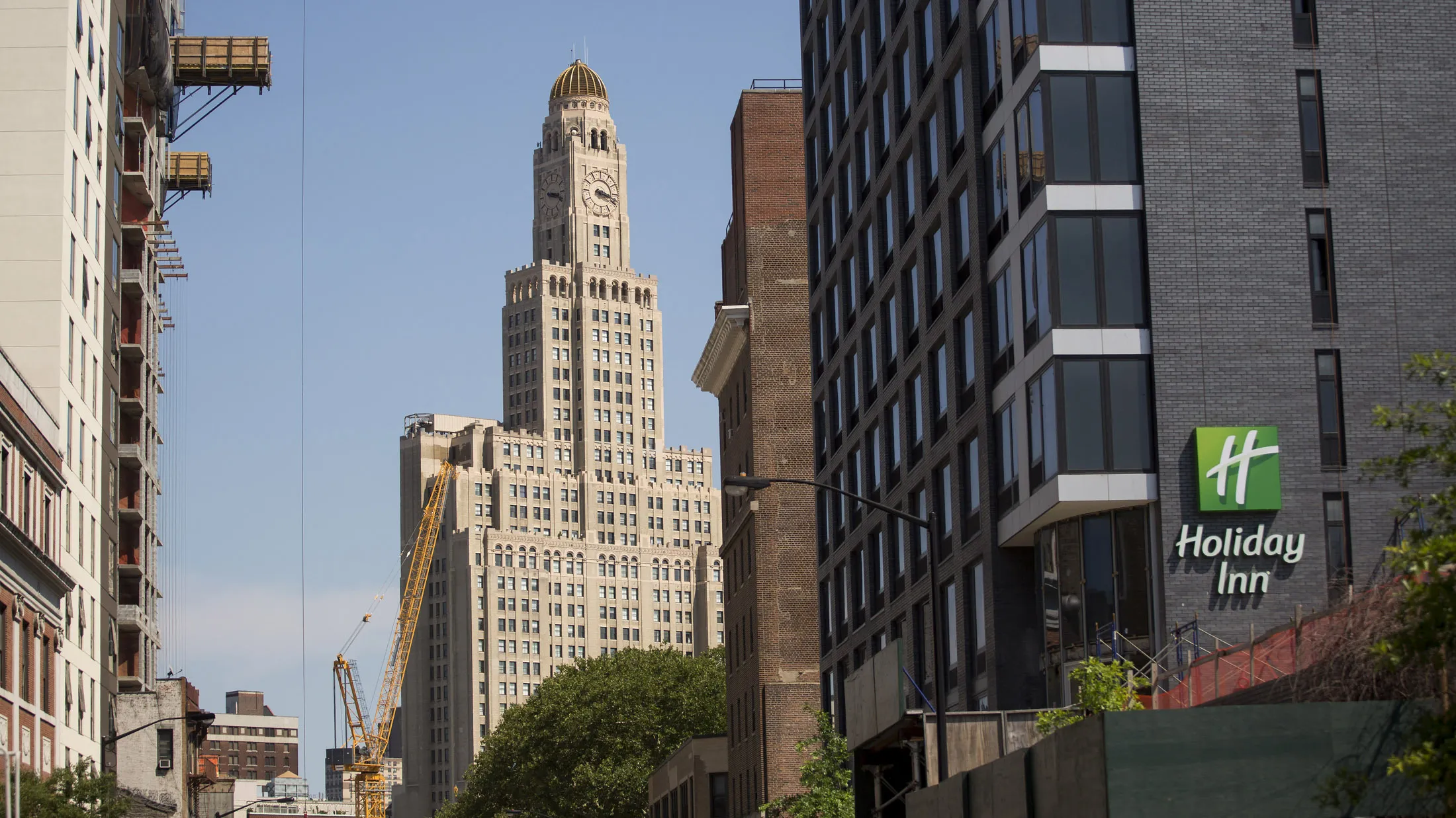 Hotel construction on each side of a street in downtown Brooklyn, July 16. Photographer: Michael Nagle/Bloomberg
