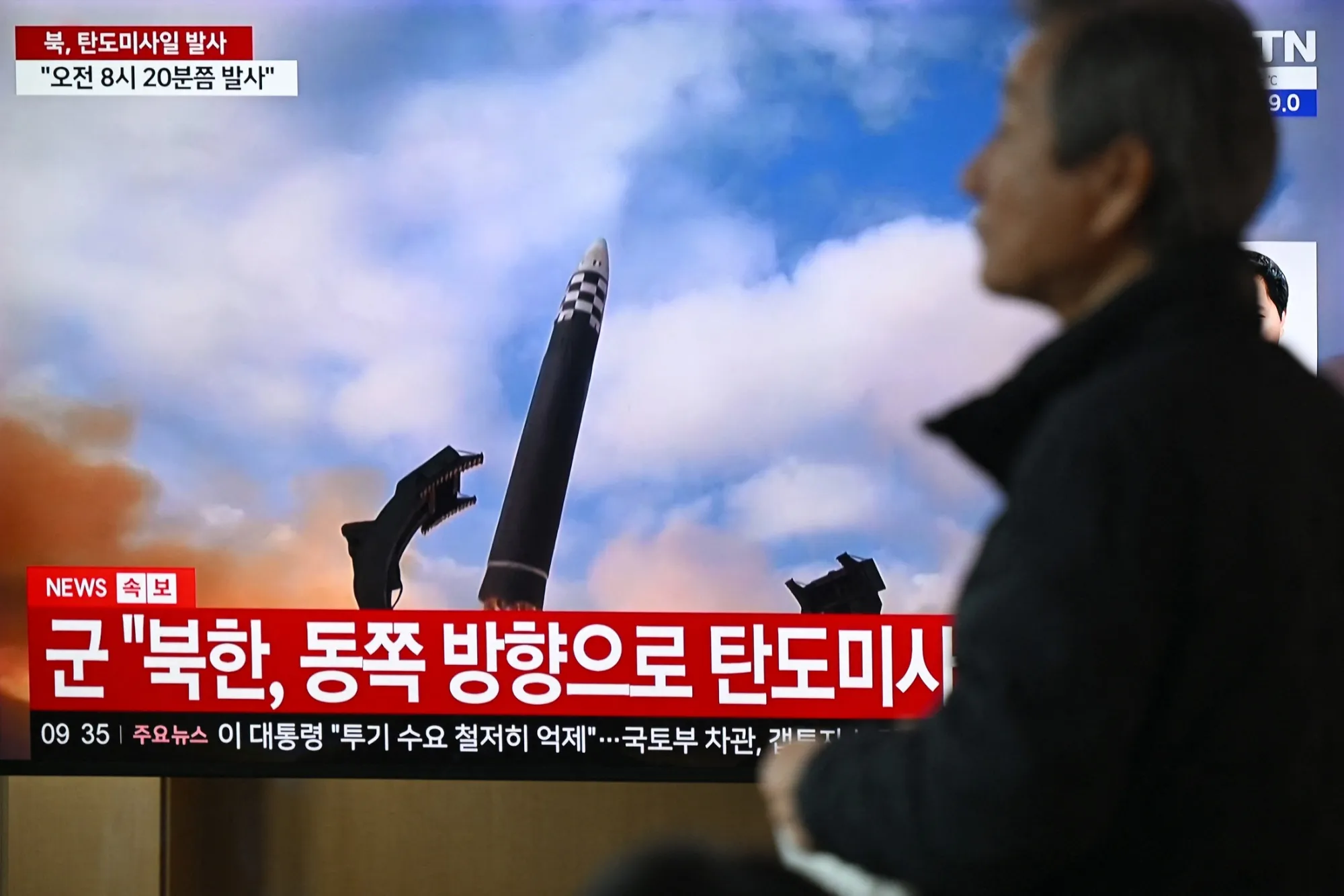 A news broadcast showing file footage of a North Korean missile test, at a train station in Seoul.