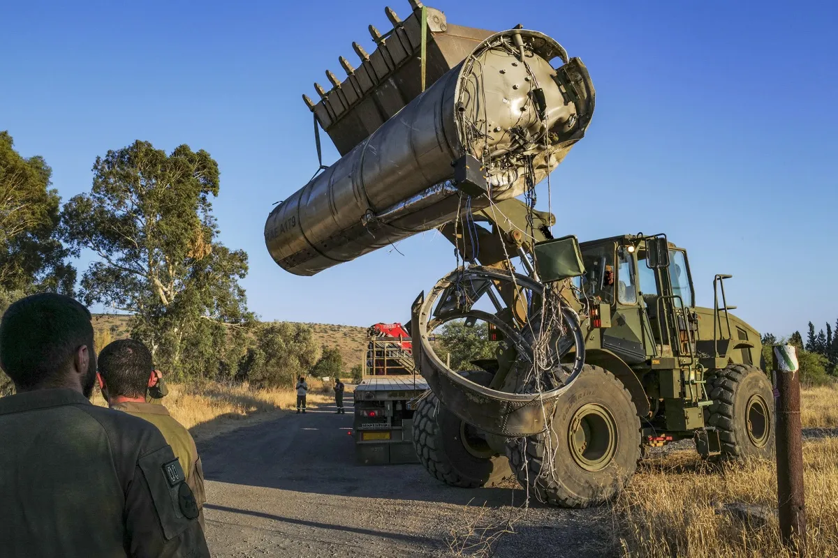 Members of the Israeli special forces use a loader to remove the apparent remains of an Iranian ballistic missile&nbsp;in Tel Aviv on June 19.