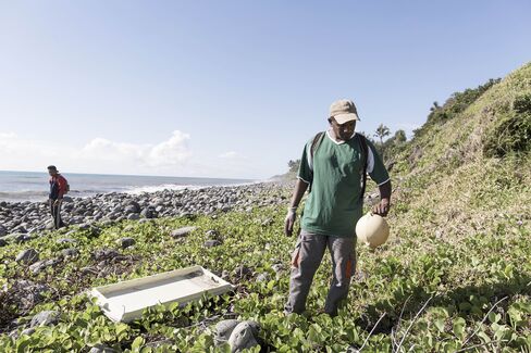 Workers look for debris of the MH370 on the coast of Saint Andre, Reunion Island in August 2015.