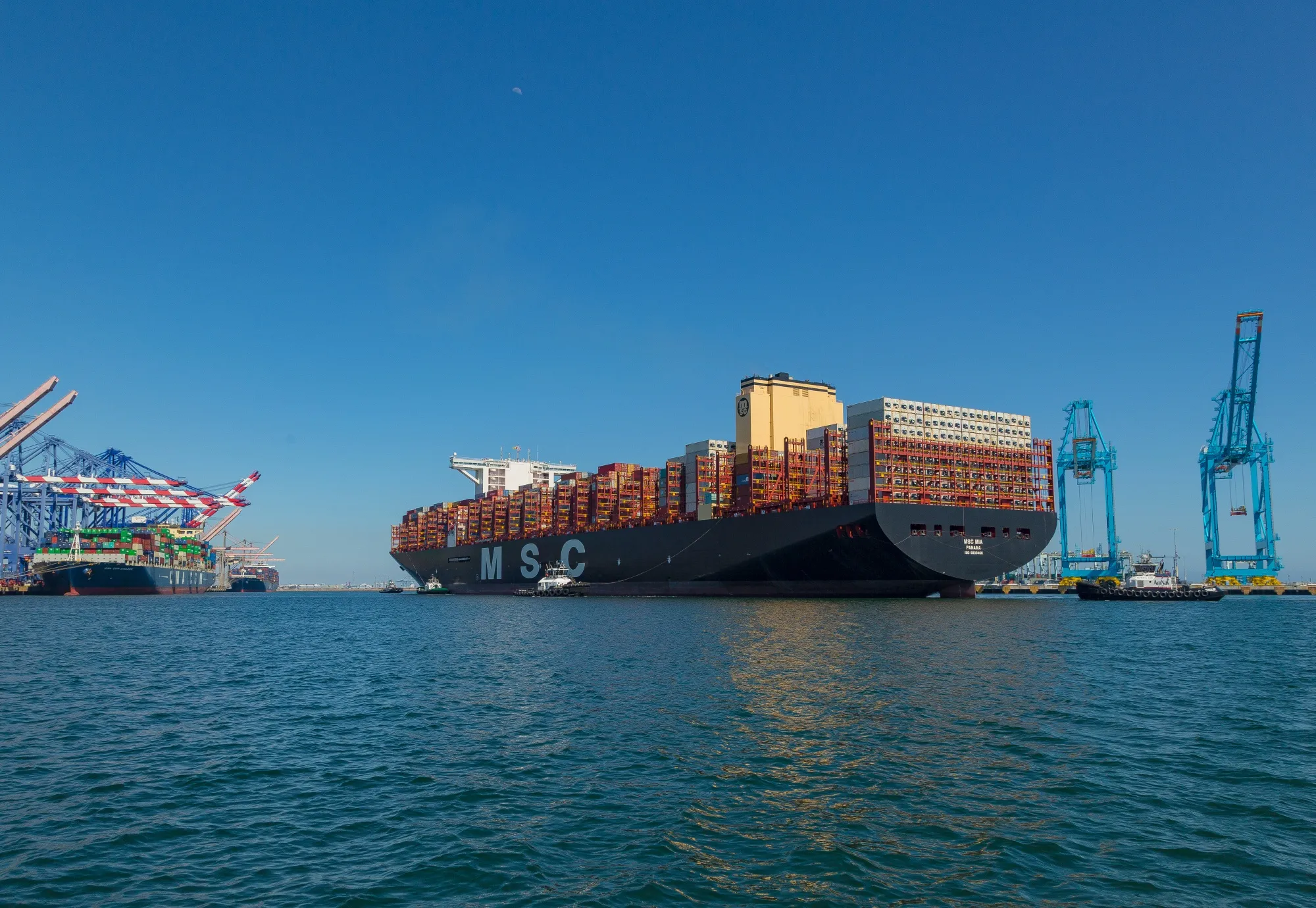 Tugboats guide the Mediterranean Shipping Co. (MSC) Mia container ship arriving at the Port of Los Angeles in Los Angeles, California, U.S., on Wednesday, April 1, 2020.&nbsp;