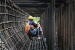 Workers labor at the construction site of an elevated highway on the outskirts of Shanghai, China, on&nbsp;June 12.