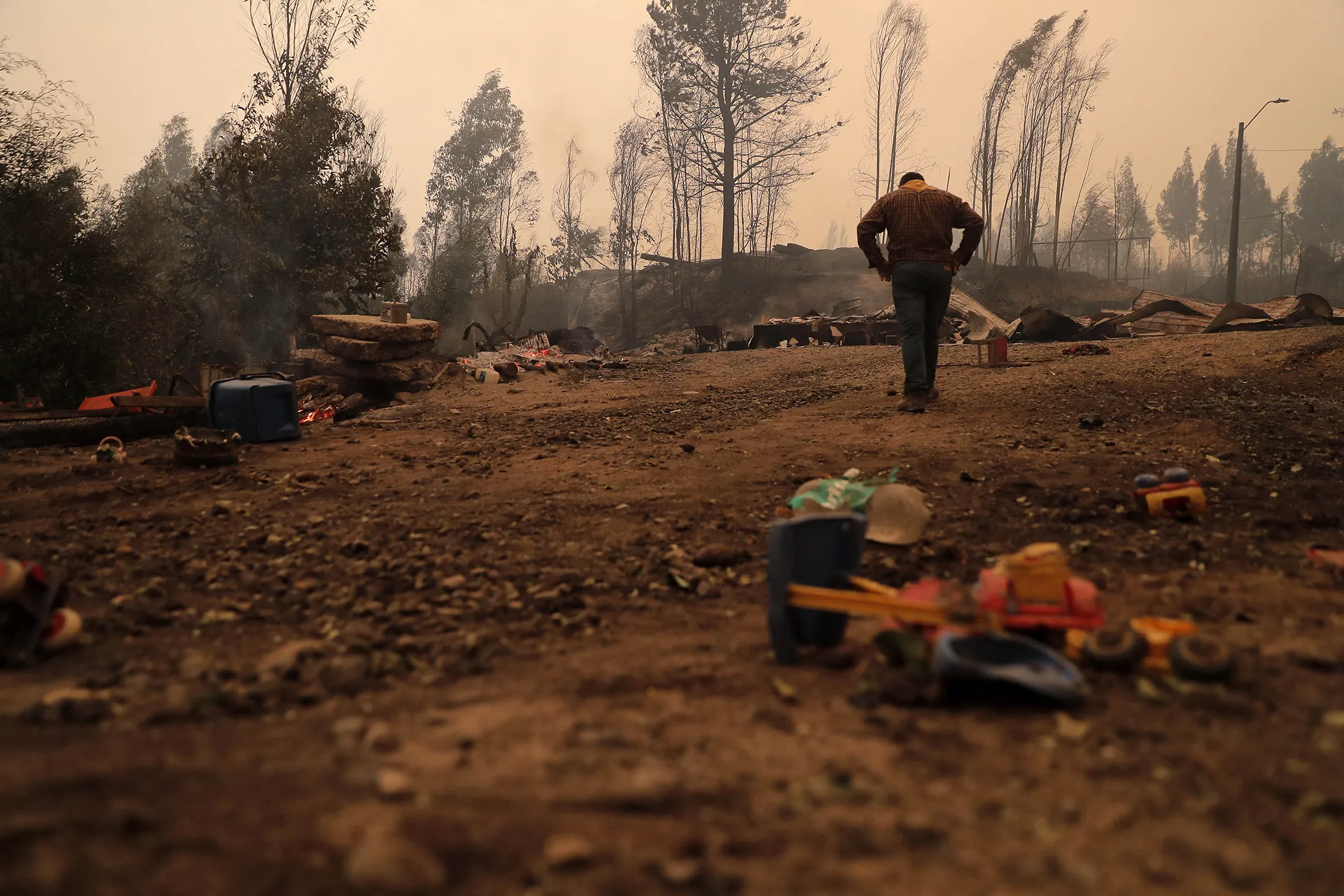 A resident surveys damage following a wildfire in Santa Juana, Concepcion province, Chile on Feb. 3.