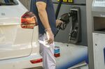 A customer wearing gloves returns a fuel nozzle at a gas station in Los Angeles, California.